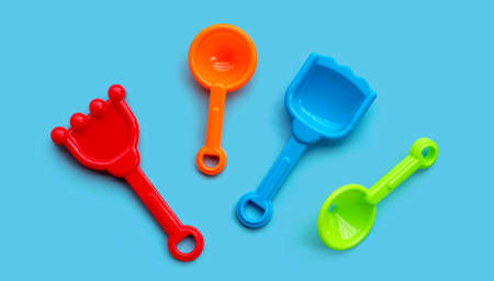 Plastic toys, shovels for sand on blue background.の写真素材