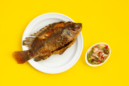 Fried fish in white plate on yellow background.の写真素材