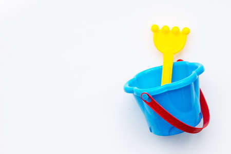 Plastic toys, shovel in bucket for sand on white surface.の写真素材