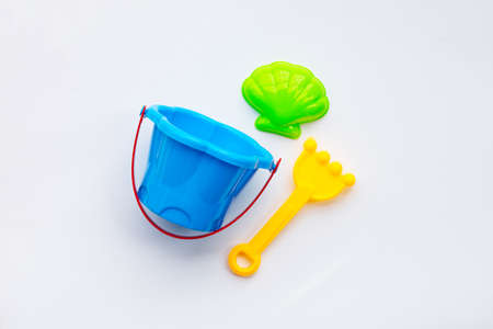 Plastic toys, shovel with bucket for sand on white surface.の写真素材