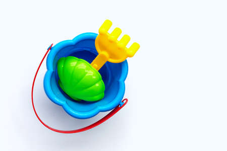 Plastic toys, shovel in bucket for sand on white surface.の写真素材