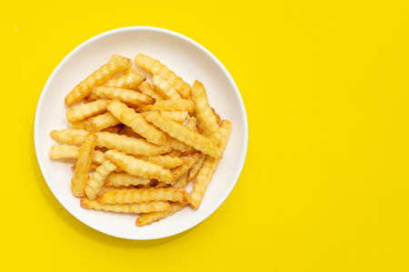 French fries in white plate on yellow background.の写真素材