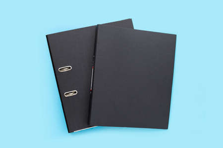 Black office folders on blue background. Top viewの写真素材