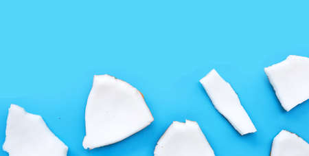 Coconut cut pieces on blue background. Top viewの写真素材