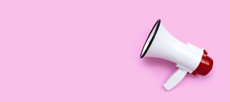Red and white megaphone on pink background.の写真素材