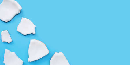 Coconut cut pieces on blue background. Top viewの写真素材
