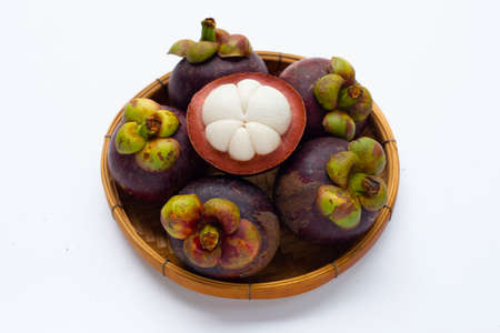 Mangosteen in bamboo basket on white background.の写真素材