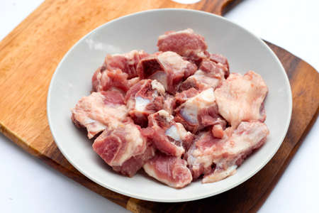 Raw pork ribs in white plate on cutting board on white background.の写真素材