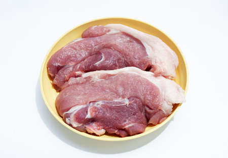 Pork meat in yellow plate on white background.の写真素材