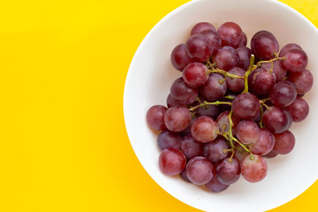 Fresh grape in white bowl on yellow background.の写真素材