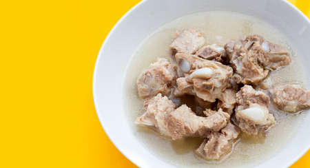 Boiled pork ribs in white bowl on yellow background.の写真素材