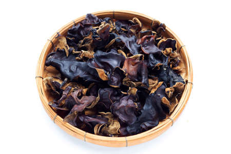 Dried black fungus in bamboo basket on white background.の写真素材