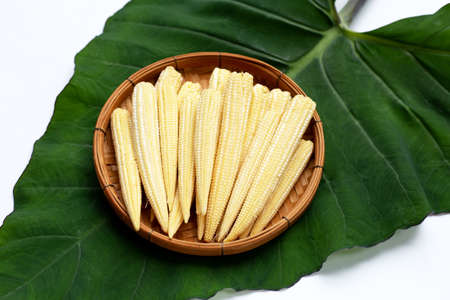 Baby corn in bamboo basket on taro leaf