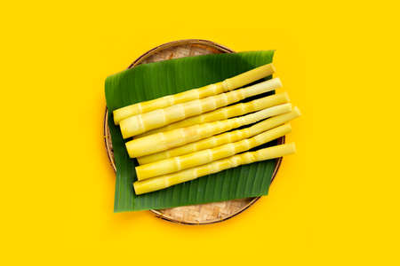 Preserved bamboo shoot in bamboo basket on yellow background.