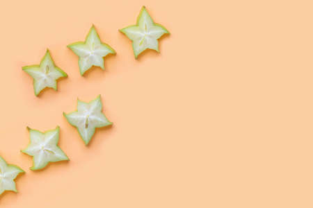 Green star fruit slices on pastel color background.の写真素材