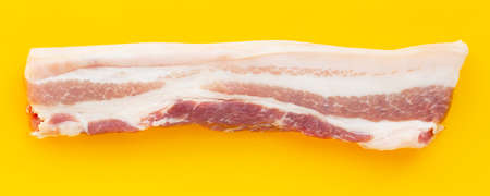 Streaky pork on yellow background.