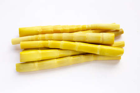 Preserved bamboo shoot in white bowl on yellow background.