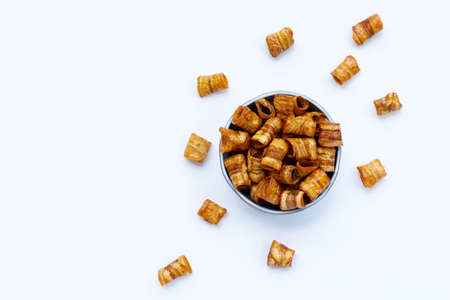 Dried banana rolled chips on white background.の写真素材