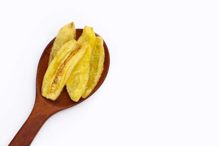 Banana slice chips in wooden spoon on white background.の写真素材