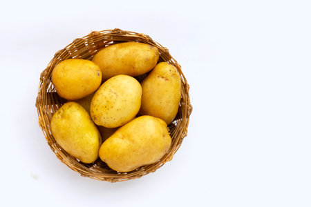 Fresh potatoes in bamboo basket on white background.の写真素材