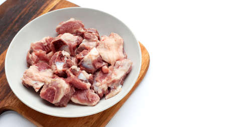 Raw pork ribs in white plate on wooden cutting boardの写真素材