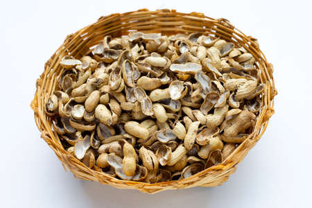 Peanut shells in bamboo basket on whiteの写真素材
