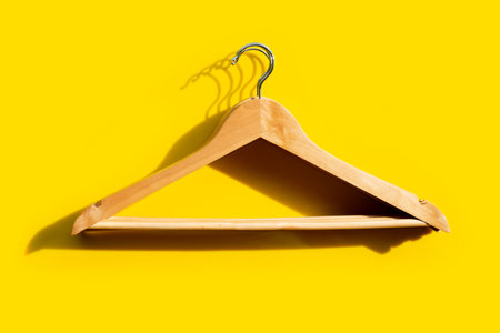 Wooden clothes hangers on yellow background.の写真素材