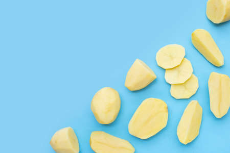 Raw peeled potatoes on blue backgroundの写真素材