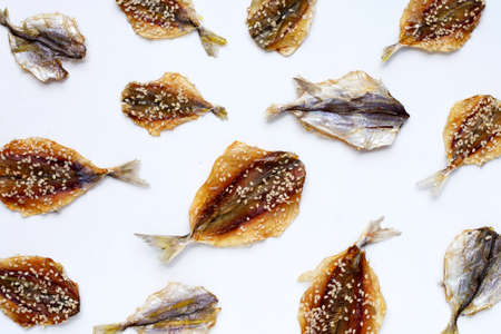 Dried fish with sesame seeds on white background.の写真素材