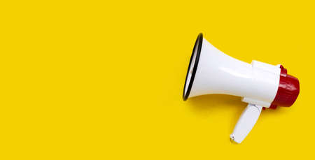 Red and white megaphone on yellow background.の写真素材