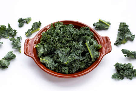 Kale leaves in brown bowl on white background.の写真素材