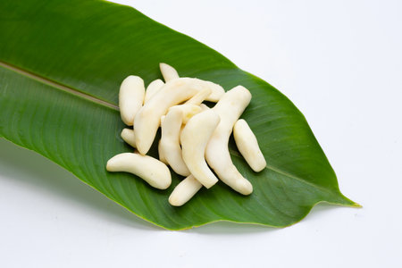 Young ginger peeled on green leaf on white background.の写真素材