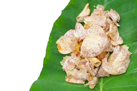Crispy taro chips on green leaf on white background.の写真素材