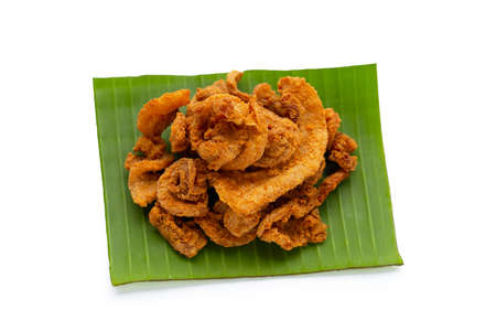 Fried crispy pork belly recipe on banana leaf on white background.の写真素材