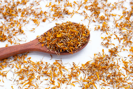 Dried marigold flower petals on white background. Flower herbal tea concept.の写真素材