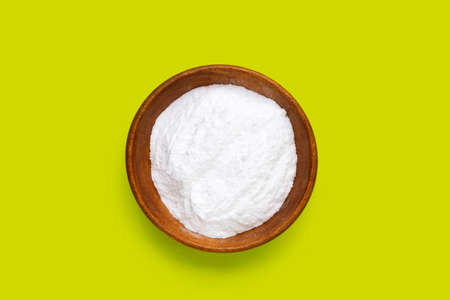 Baking soda in wooden bowl on green background.の写真素材
