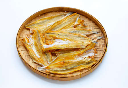 Sun dried black kingfish in bamboo basket on white background.の写真素材