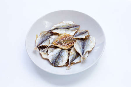 Dried fish with sesame seeds in white plate on white background.の写真素材