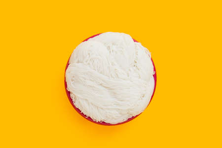 Thai rice noodle in red plastic basket on yellow background.の写真素材