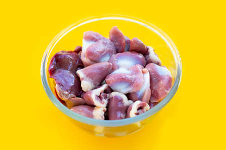 Mixed chicken entrails in glass bowl on yellow background.の写真素材