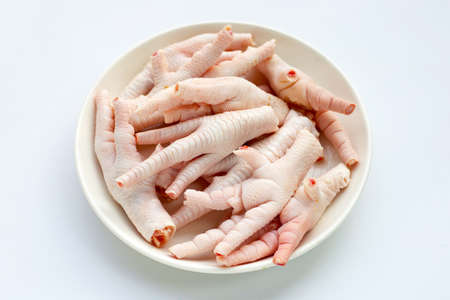 Raw chicken feet in white plate on white backgroundの写真素材