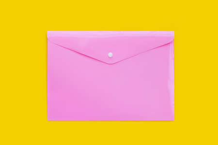 Pink plastic bag folder on yellow background.の写真素材