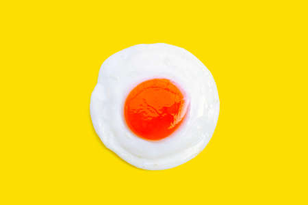 Fried egg onyellow background. Top viewの写真素材
