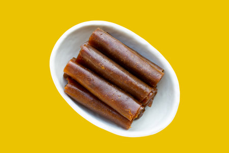 Dried mango paste in white bowl on yellow background.の写真素材