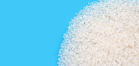 Raw rice on blue background.の写真素材