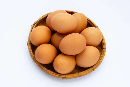Fresh eggs in bamboo basket on white background. Copy space