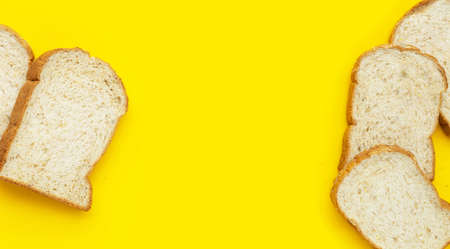 Sliced wholegrain bread on yellow background.