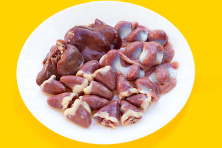 Mixed chicken entrails in white plate on yellow background.の写真素材