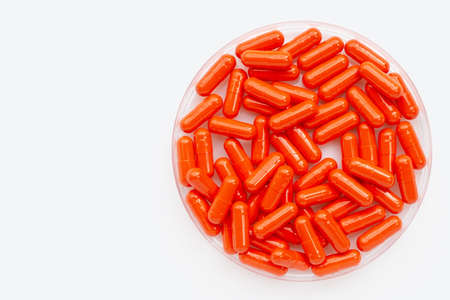 Orange capsule pills on white background.の写真素材