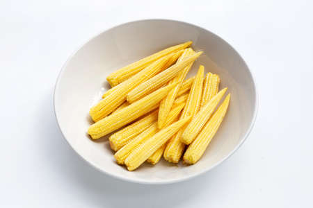 Baby corn in white bowl on white background.の写真素材